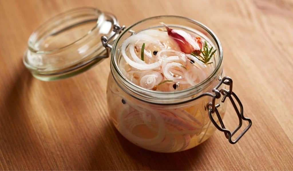 An open jar of pickled onions. 