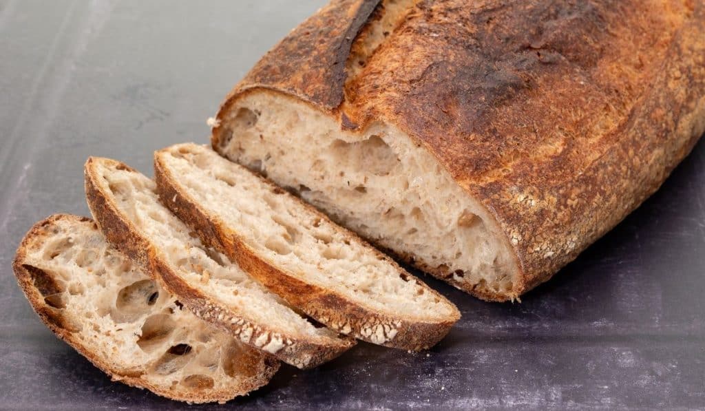 Sourdough loaf, partially sliced. 